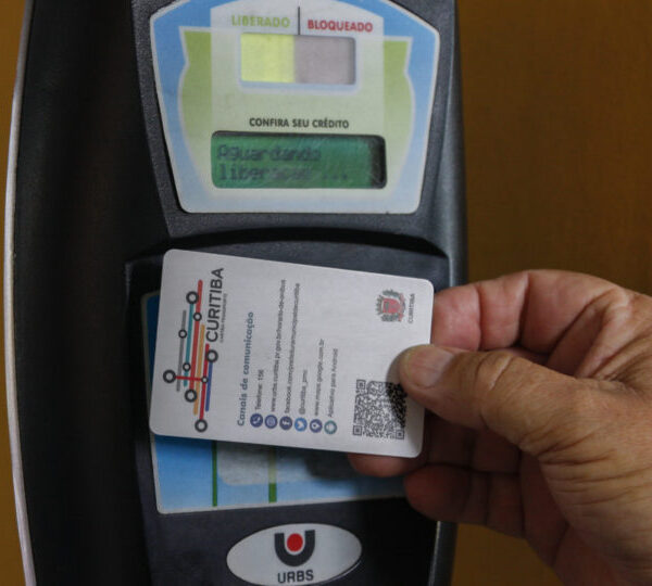 a sua empresa é obrigada a pagar vale-transporte? Imagem com o cartao transporte passando no leitor de Curitiba