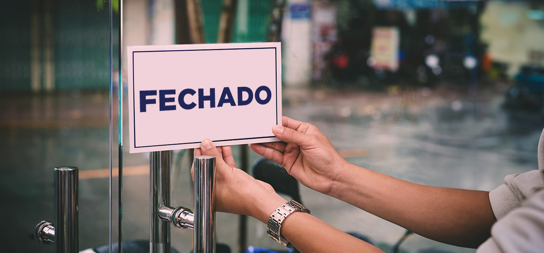 imagem de um mercado com a placa "Fechado" em plano detalhe